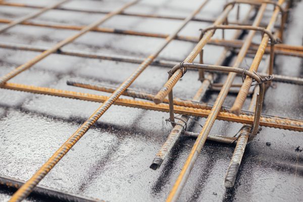 Reinforcement rods at construction site. Steel rebar mesh close up. Rusty steel reinforcement bars for concrete foundation or ceiling. Process of house building